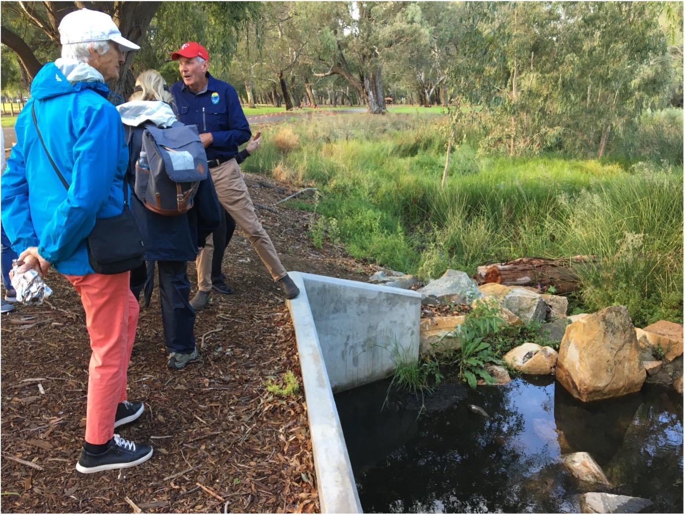 A group of people standing next to a small stream

Description automatically generated with low confidence